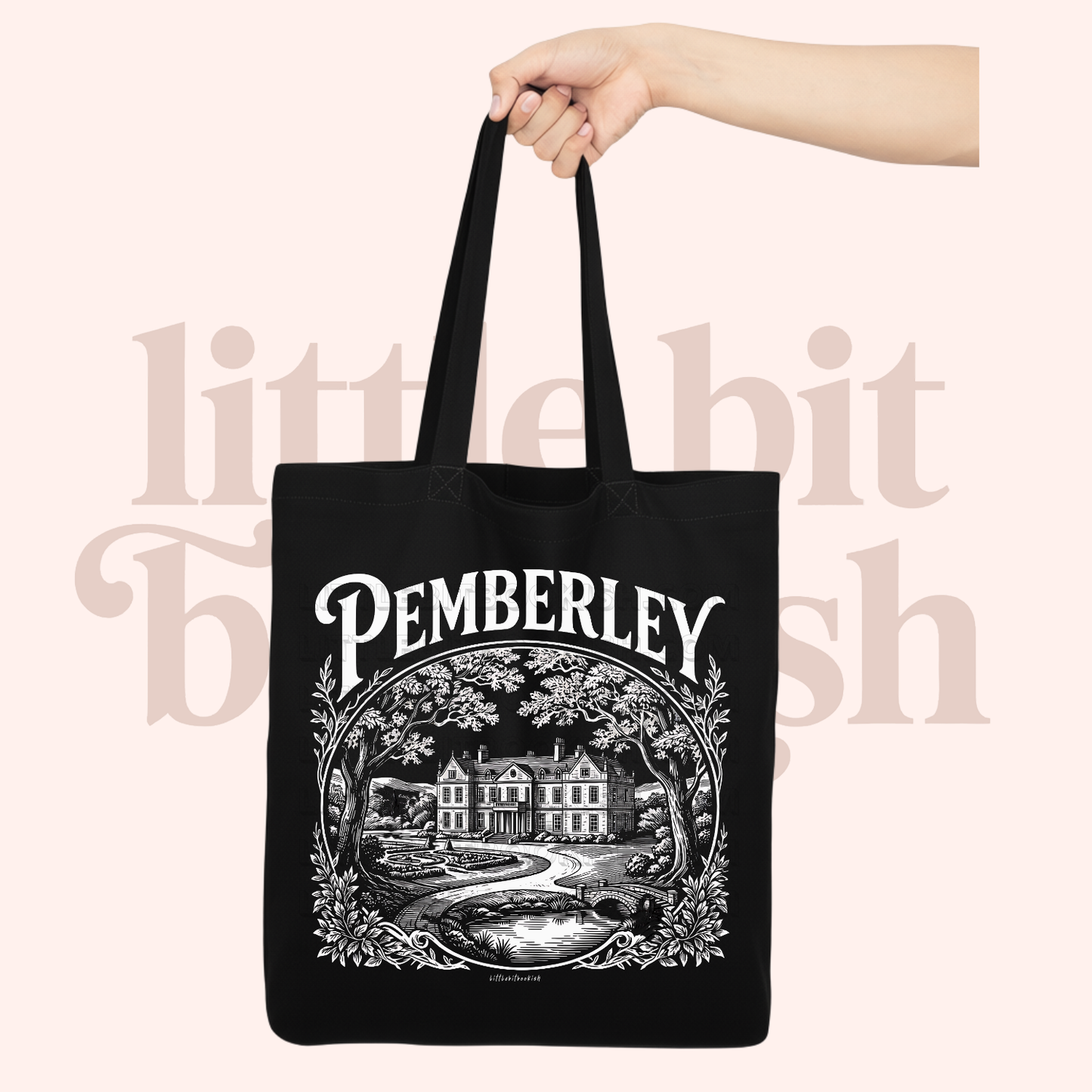 Black tote bag with 'Pemberley' design held by a hand on a light pink background.
